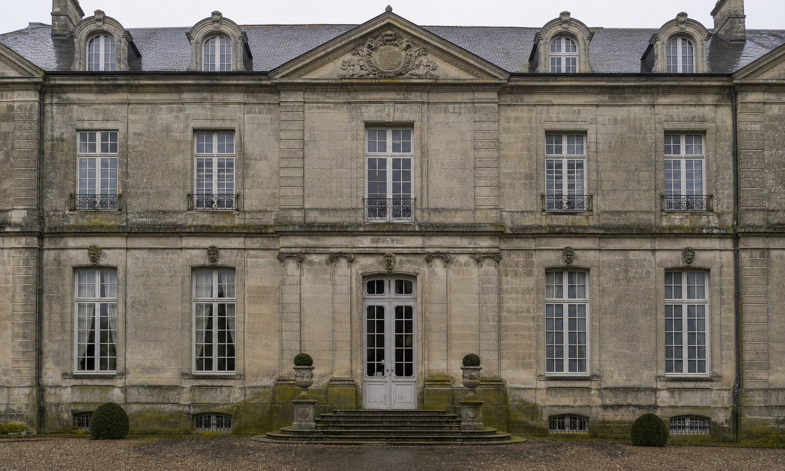 Façade de château en pierre avant nettoyage, marquée par la pollution et les mousses